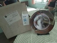 Front of plate on stand next to original box