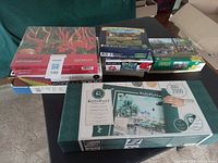 Stack of eight puzzle boxes and roll-up mat on table