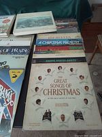 Stacked vinyl records; visible The Great Songs of Christmas, Andre Kostelanetz, Jim Reeves, A Christmas Present, Hymns of Praise, Alabama – Roll On