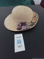 Top and side view of straw hat showing purple flower decoration
