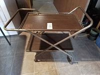 Full view of tea cart upright showing two shelves and X-frame