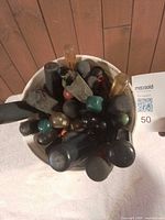 Top-down view into pail showing numerous screwdriver handles of different colors and sizes