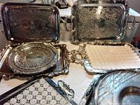 Overall view showing six different silver-tone serving trays and dish