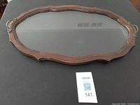 Top view of oval wood and glass serving tray with metal handles