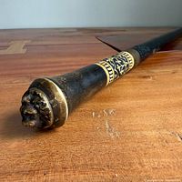 Overall view of sword cane lying on wooden surface