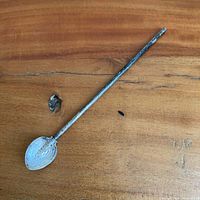 Full view of sterling spoon straw on wooden surface