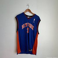 Full front view of blue Knicks #3 jersey on hanger