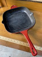 Top view showing ridged black interior and red handle