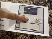 Box top showing installed white cable raceway under wall-mounted TV