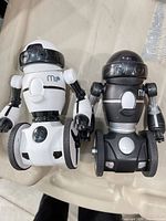 Front view of both white and black MiP robots standing side-by-side