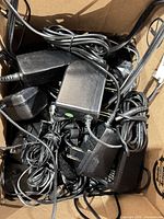 Box containing bundled AC adapters and cords