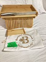 Bread slicer folded with knife resting on tray and storage bag below