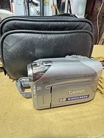 Left side view of Canon Elura 100 camcorder beside black case