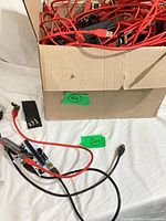 Open box filled with red USB 3.0 cables and black PCIe riser boards