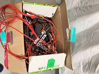 Open box filled with riser boards and red cables