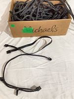 Box containing numerous black sleeved PSU cables