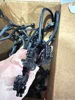 Box of multiple black braided PCIe power cables showing connector ends