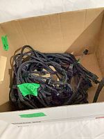Box containing numerous black braided power supply cables