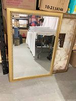 Full view of rectangular gold framed mirror
