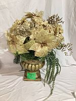 Full view of gold and green artificial floral arrangement in urn