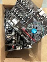 Box containing several ASUS B250 Mining Expert motherboards, some with Intel stock coolers attached