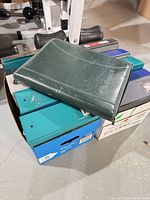 Stack of assorted binders in box showing colors and quantity