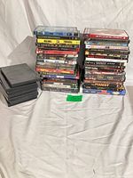 Three stacks of DVD cases, approximately 35 total, some blank cases visible
