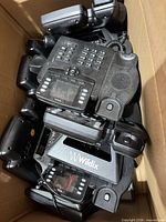 Box containing stack of black Wildix desk phones