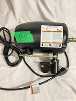 Side view of black oscillating motor showing power cord, mounting bracket, shaft