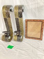 Full view of both metal sconces and wood frame