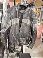 Front view of Teknic leather motorcycle jacket hanging, showing overall styling and condition