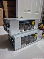 Two stacked silver TF2000W-A-ATX PSUs showing rear fans and cabling