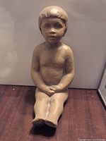 Front view of seated child sculpture