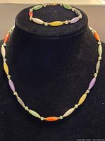 Necklace on bust with bracelet above, showing overall design and colour variety