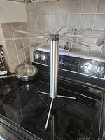 Rack fully assembled with arms extended on stovetop