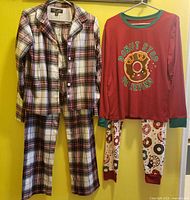 Two pajama sets on hanger: plaid flannel set and donut graphic set