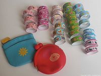 Full lot view: 30 washi tape rolls grouped by design, two coin purses placed below
