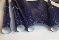 Four rolls of blue paper with gold stars, ends visible