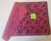 Stack of folded dark pink tissue paper with black icon design