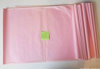 Stack of folded light pink tissue paper sheets