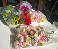 Overview showing five bags of assorted artificial flowers and foliage on table
