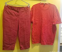 Red capri pants and red crew neck T-shirt hanging side by side