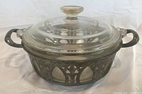 Front view of glass casserole with lid inside silver-plated holder