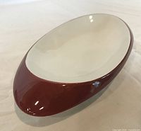Oblique view showing brown exterior and white interior of oval bowl