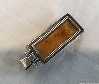 Front view of rectangular amber pendant in sterling silver bezel