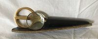 Scissors and magnifying glass partially inserted in black leather sheath