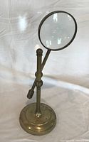full view of brass magnifier on base