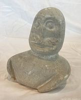 Front view of soapstone figure showing facial details and chips