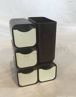 Front view showing five white-front drawers and pen holder