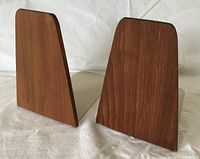 Front angled view of both teak panel bookends showing wood grain and shape